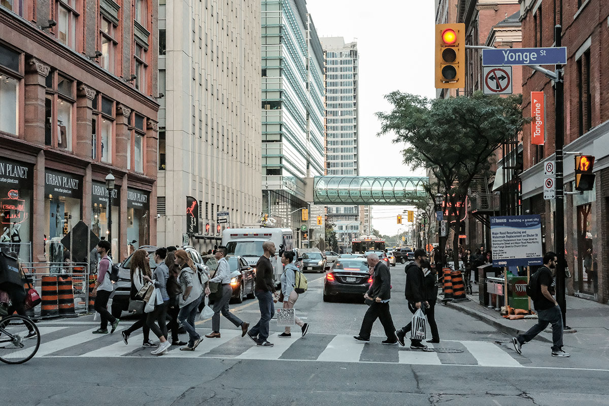 Des piétons traversent un carrefour bien rempli de monde sur une rue dans l’Ontario.